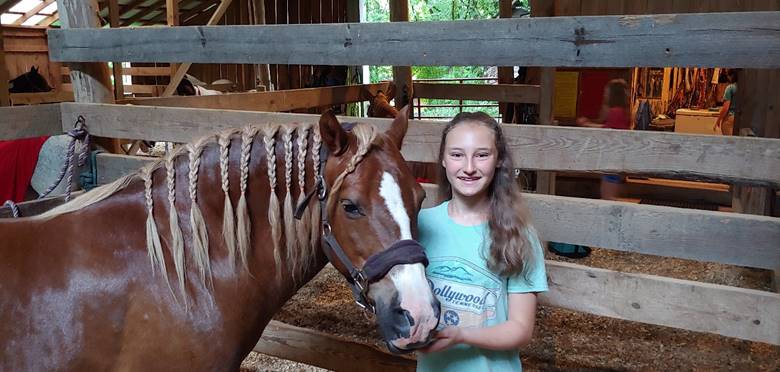 A child sitting next to a horse

Description automatically generated with low confidence